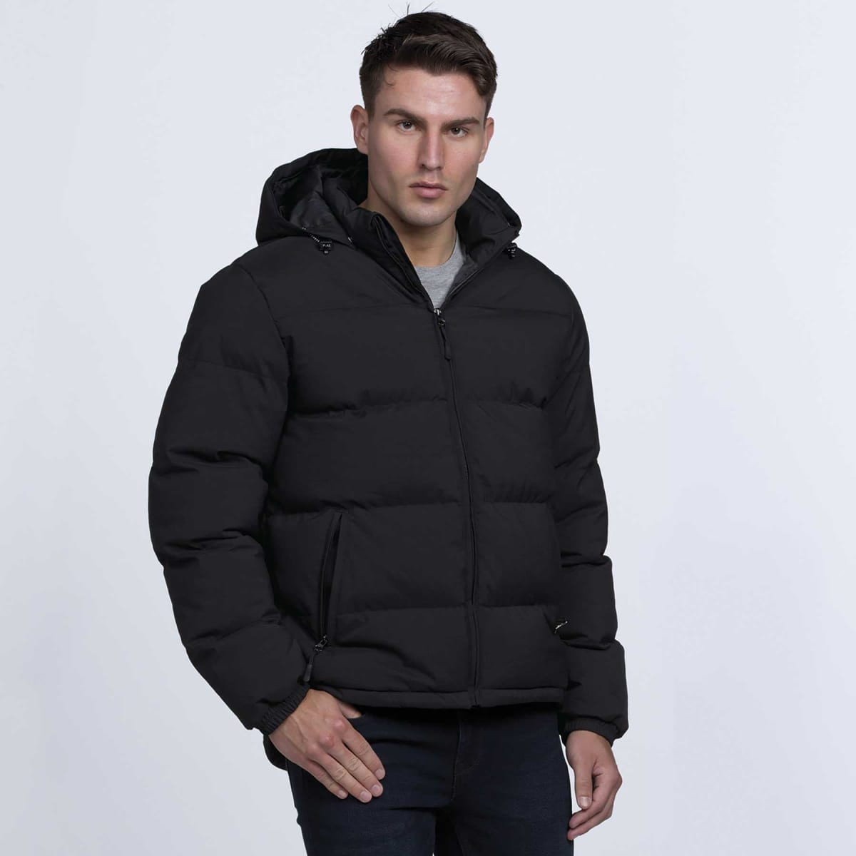 A black puffer jacket with a hood, zip closure, and side pockets, worn by a person standing against a plain background.