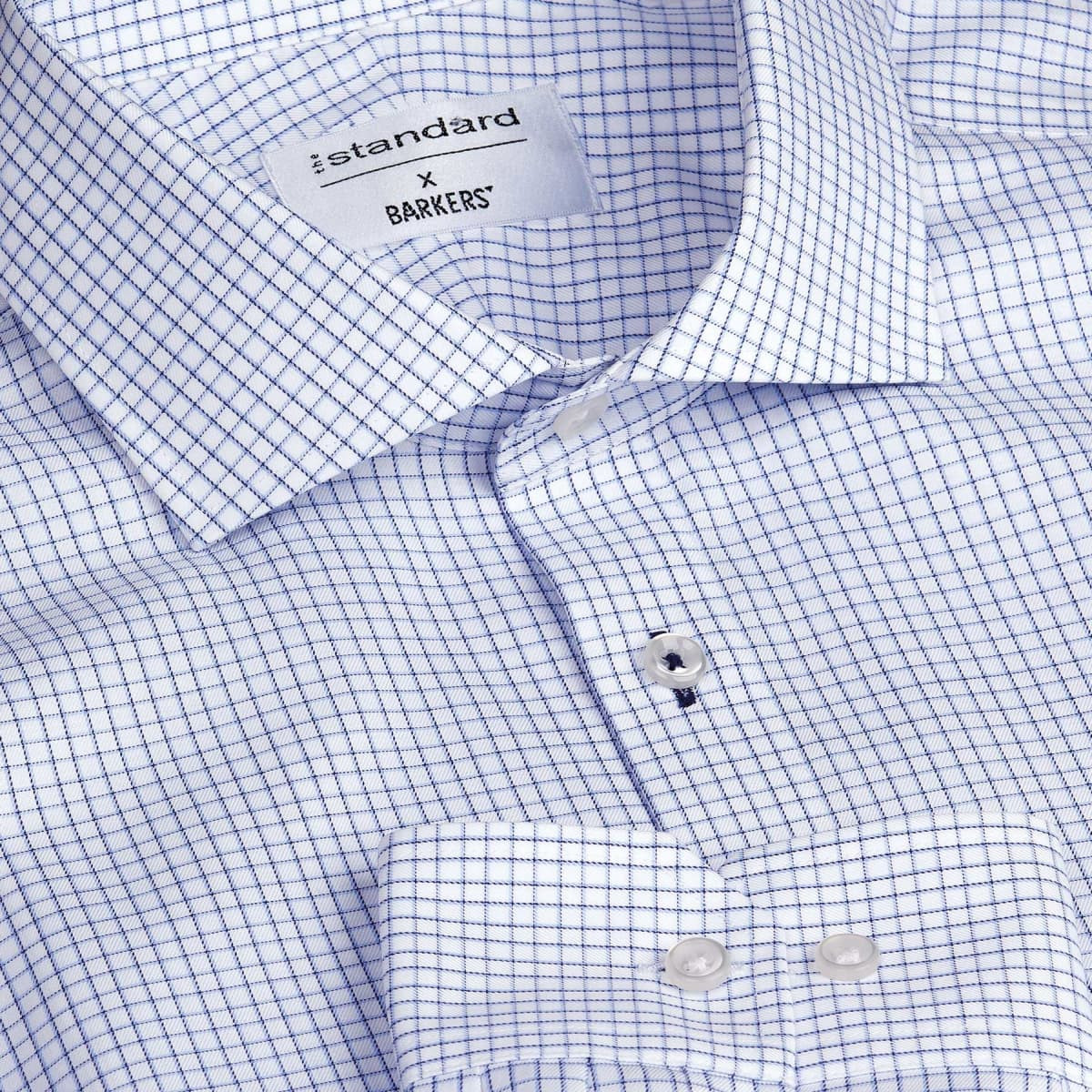 A blue and white check button-up shirt with a collar and a branding label inside.