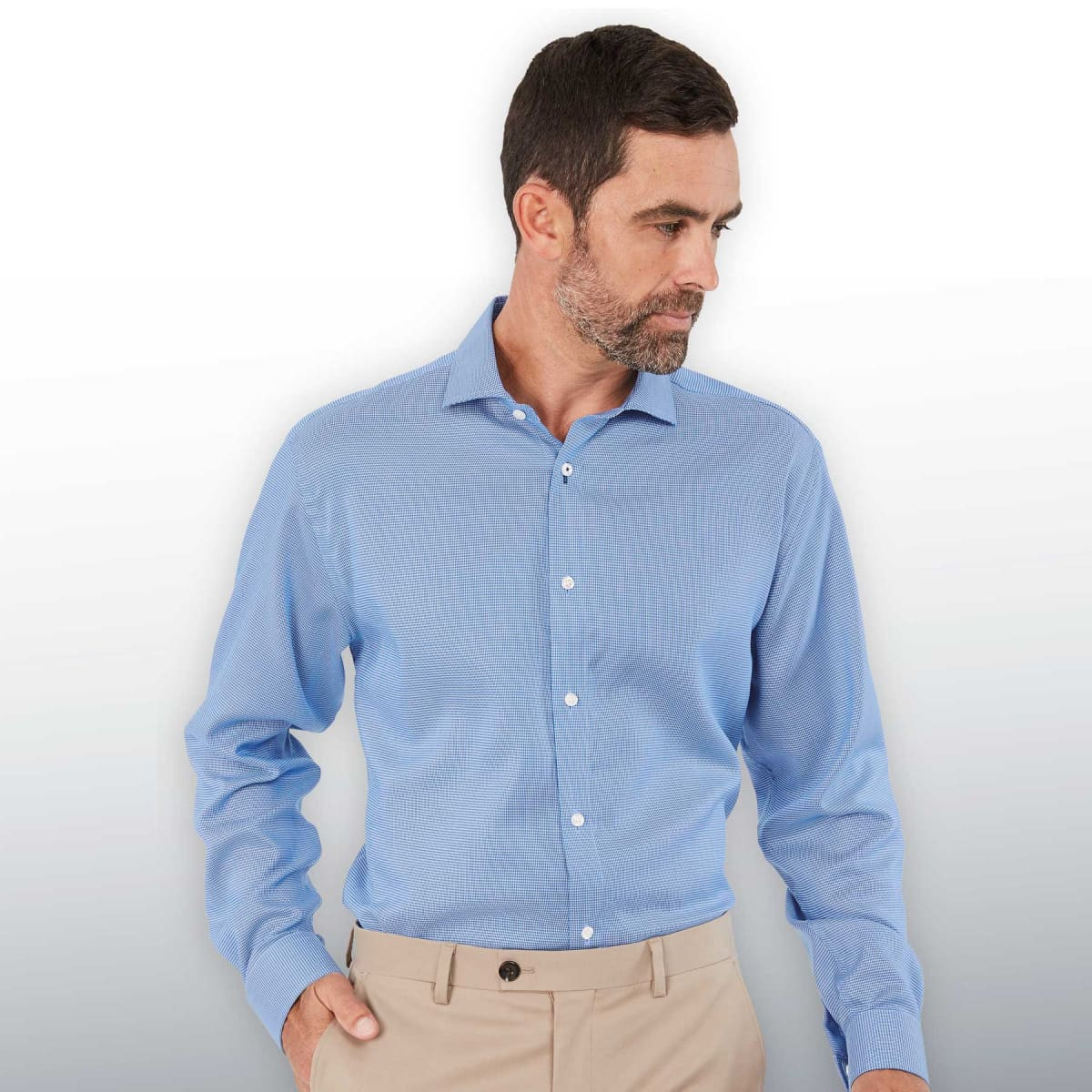 A men's button-up shirt in light blue, featuring a collar and long sleeves, with a subtle pattern and a logo.