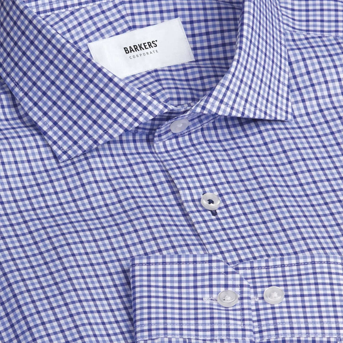 A blue and white check patterned button-up shirt with a collar and buttons, featuring a logo label inside.