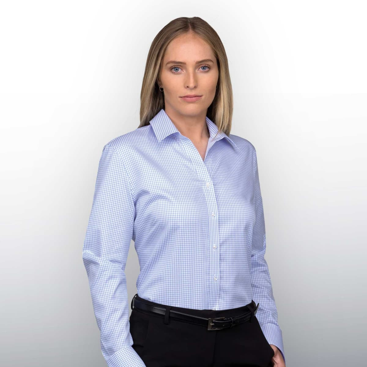 Women's button-up shirt in a light blue check pattern, featuring a collar and long sleeves. It has a branding logo.