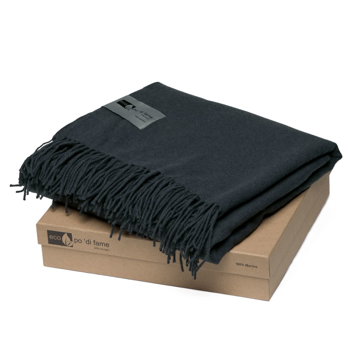A dark grey Merino blanket with fringe, neatly folded on a brown box. The blanket is made from 100% Merino wool.