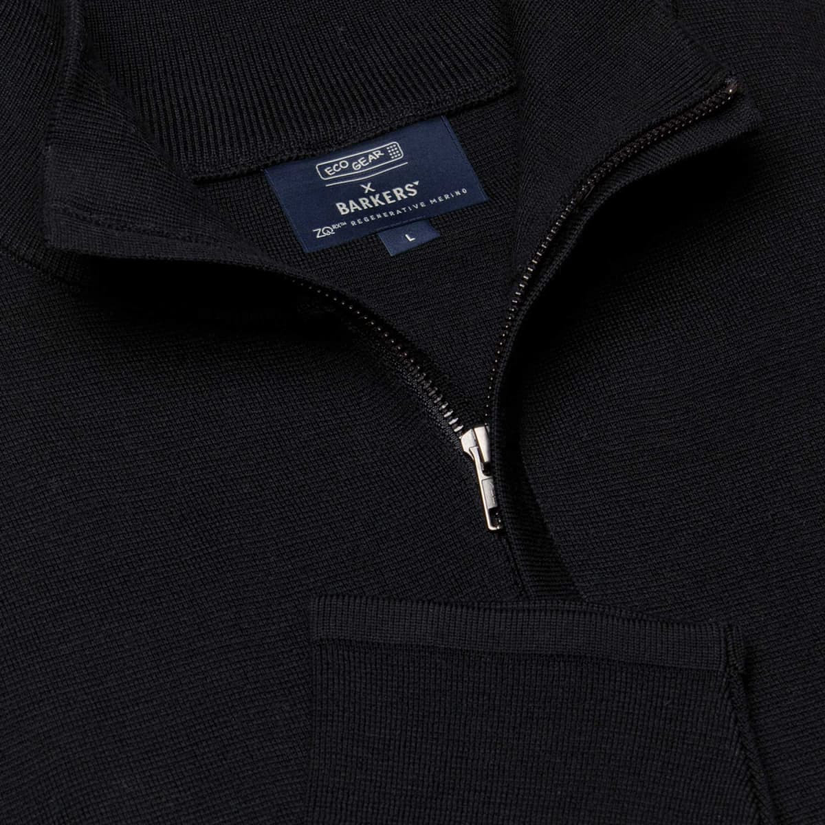 A black zip-neck shirt featuring a pocket and a logo label. Ideal for casual wear.