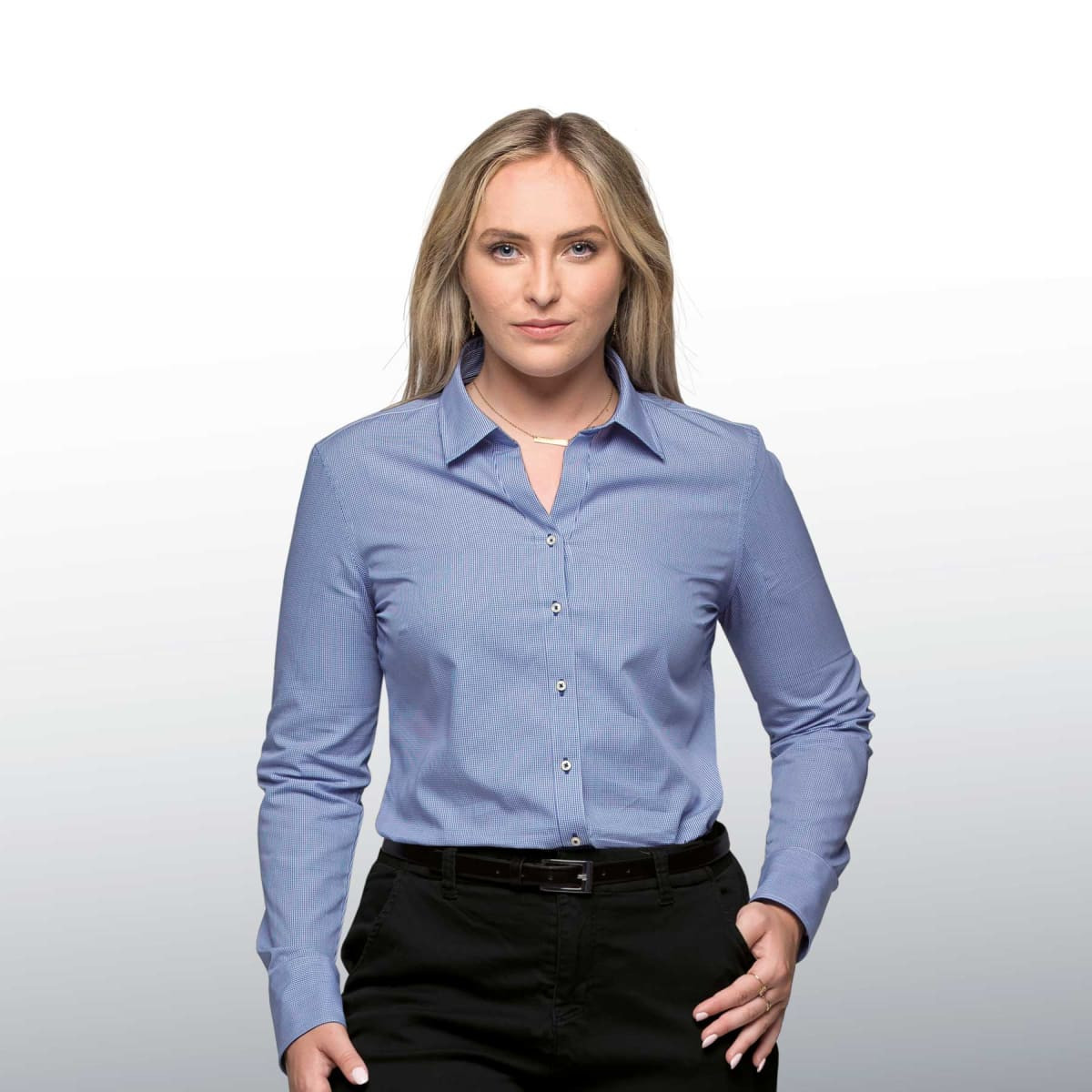 A women's button-up shirt in light blue with a collar and long sleeves, featuring a branding logo.