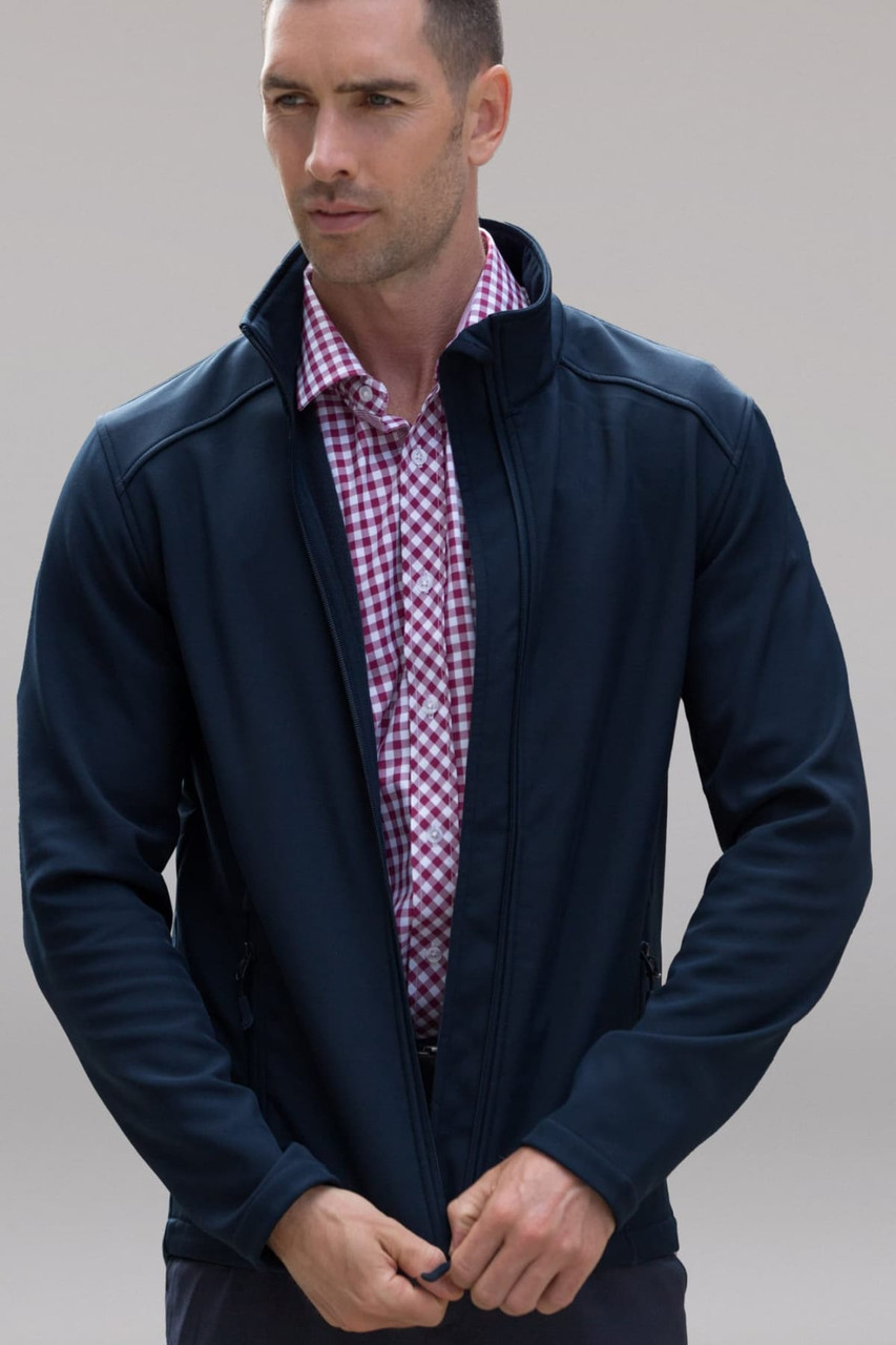A navy soft shell jacket worn by a man, featuring a zippered front and a collar. It has a logo on it.
