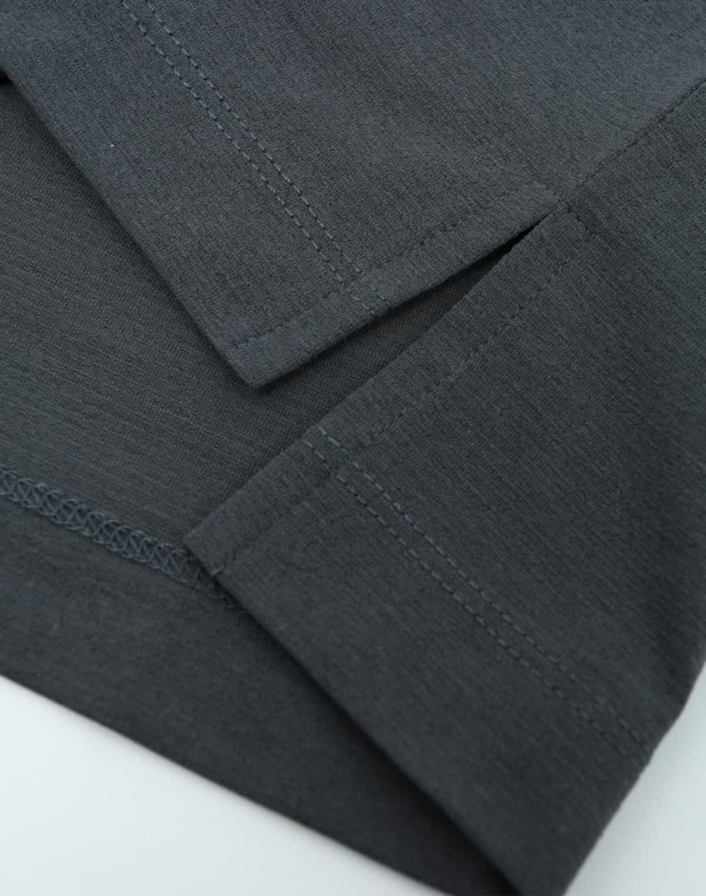 A close-up view of a grey polo shirt showcasing the fabric and stitching details. It features short sleeves and a logo.