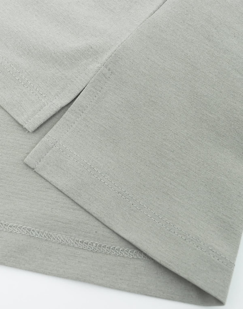 A close-up of a grey high-performance polo shirt, highlighting the fabric texture and neatly stitched hems.