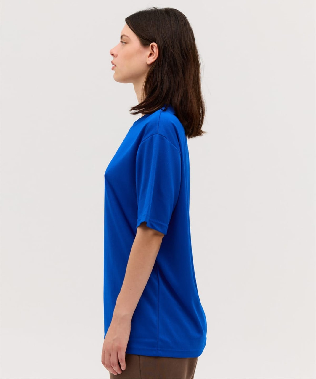 A blue T-shirt with short sleeves displayed on a model from the side, featuring a logo.