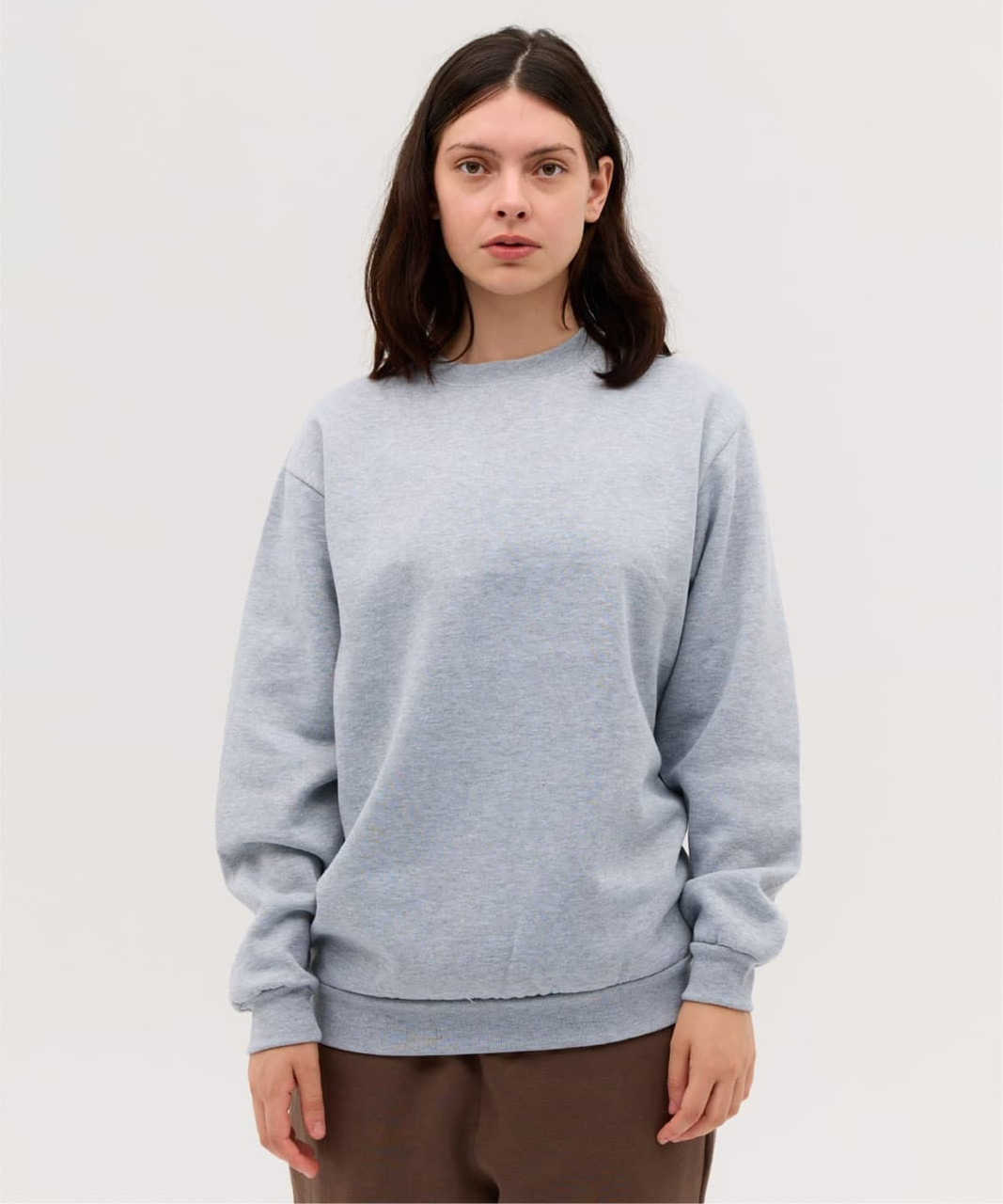 A light blue crew jumper with long sleeves, featuring a simple design and a subtle logo.