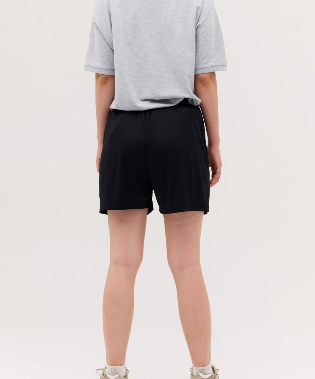 Black sports shorts shown from the back, paired with a grey t-shirt. The shorts feature a logo.