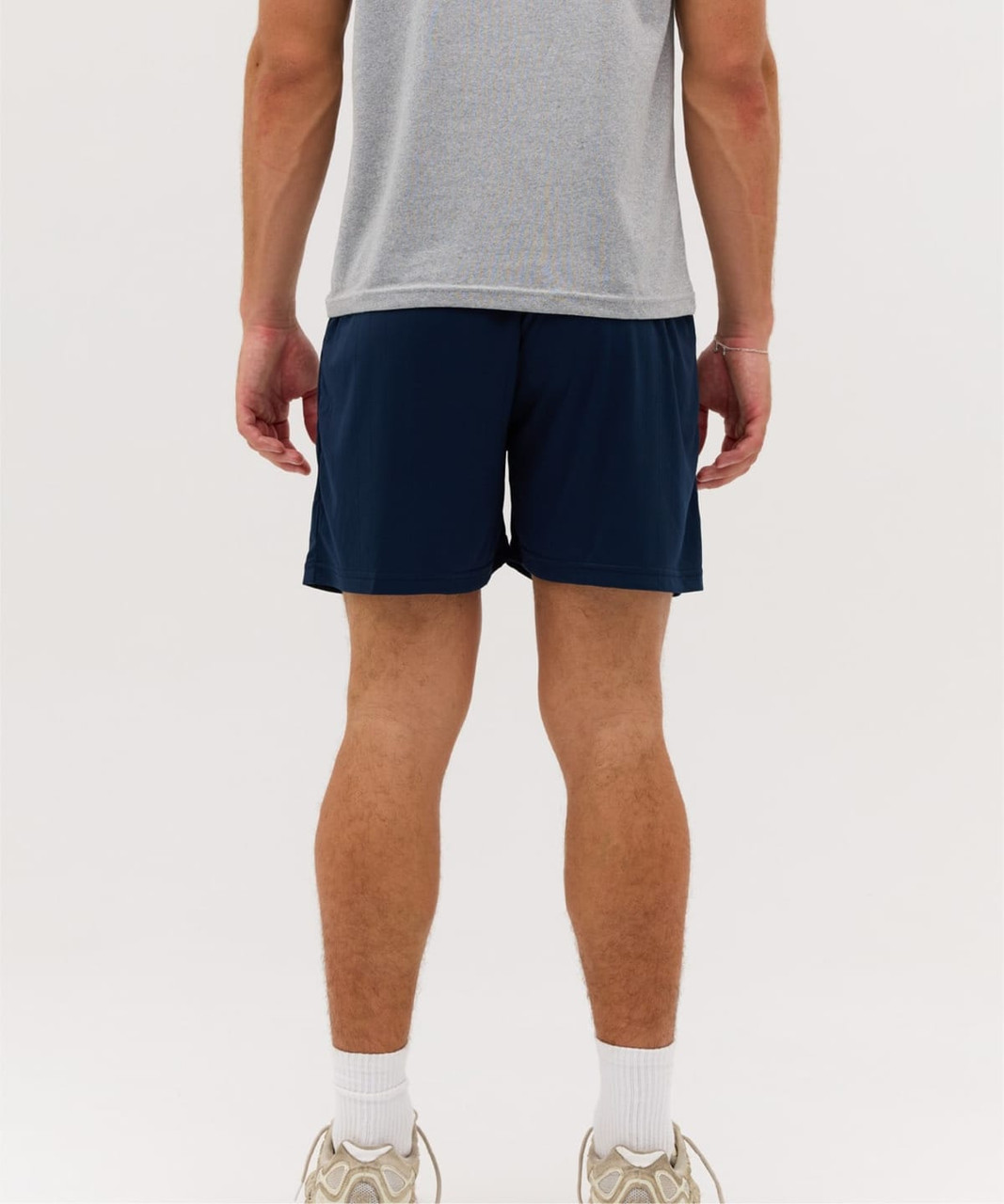 Core Shorts in navy blue, featuring a simple design and a loose fit, with a person wearing them from the back.