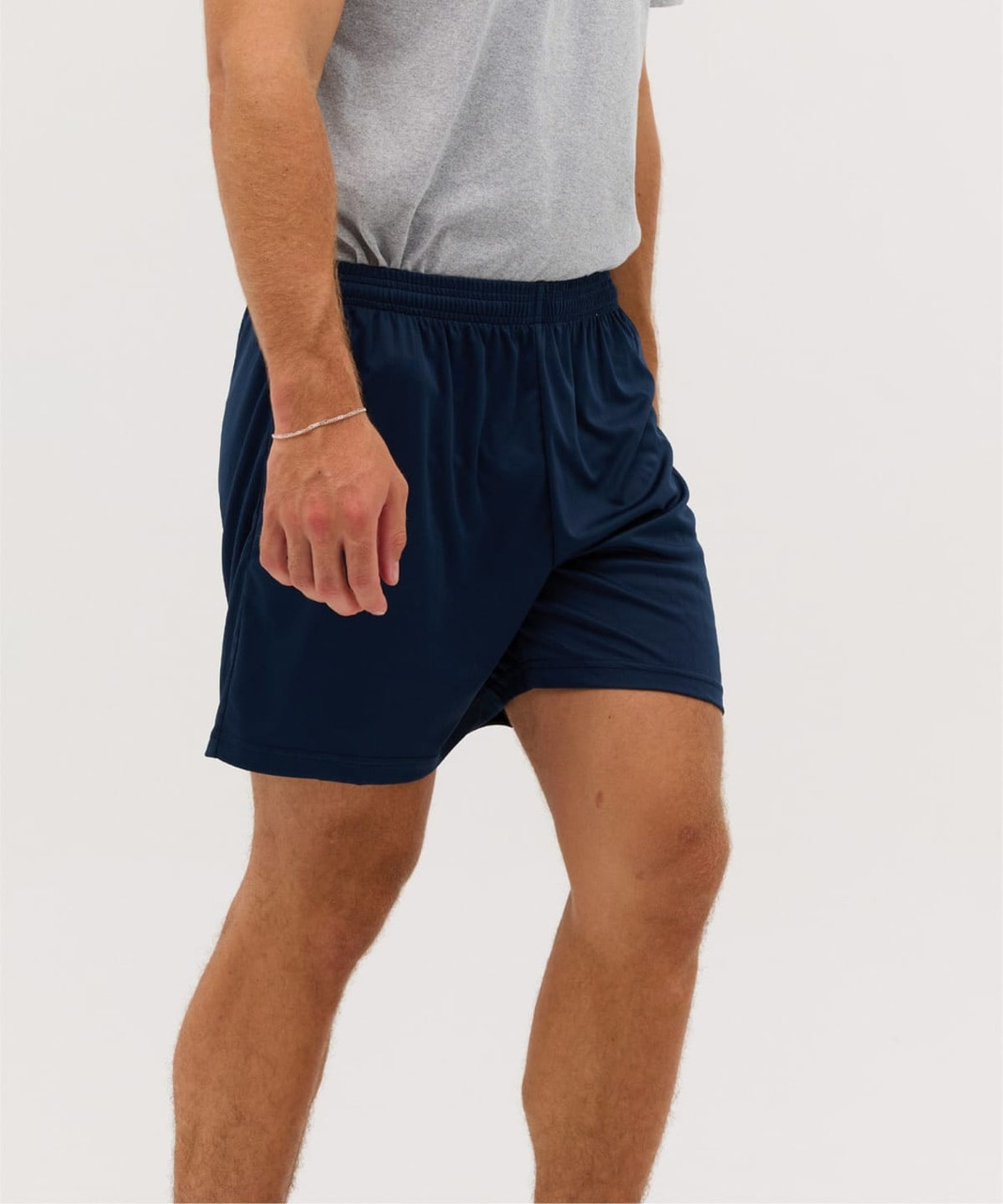 A man wearing navy blue sports shorts with an elastic waistband, paired with a grey t-shirt.