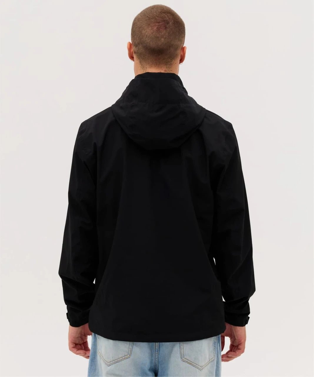 A black rain jacket with a hood, featuring a simple design and a logo on the back.