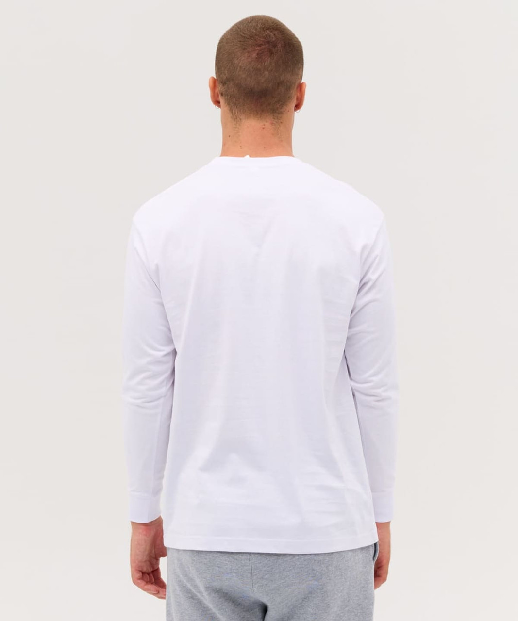A white long sleeve tee with a simple design, featuring a logo on the back, displayed on a model.