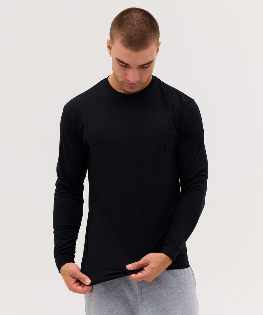 A black long sleeve tee displayed on a model, featuring a fitted design and a smooth fabric finish.