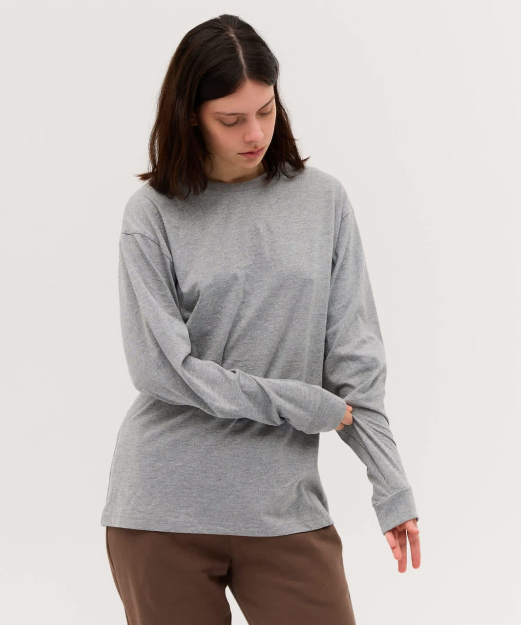 A long sleeve tee in grey, with a relaxed fit and a simple design, featuring a branding logo.