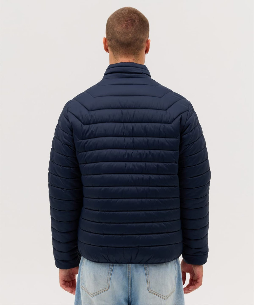 A navy blue puffer jacket with a high collar and horizontal quilting, featuring a logo on the back.