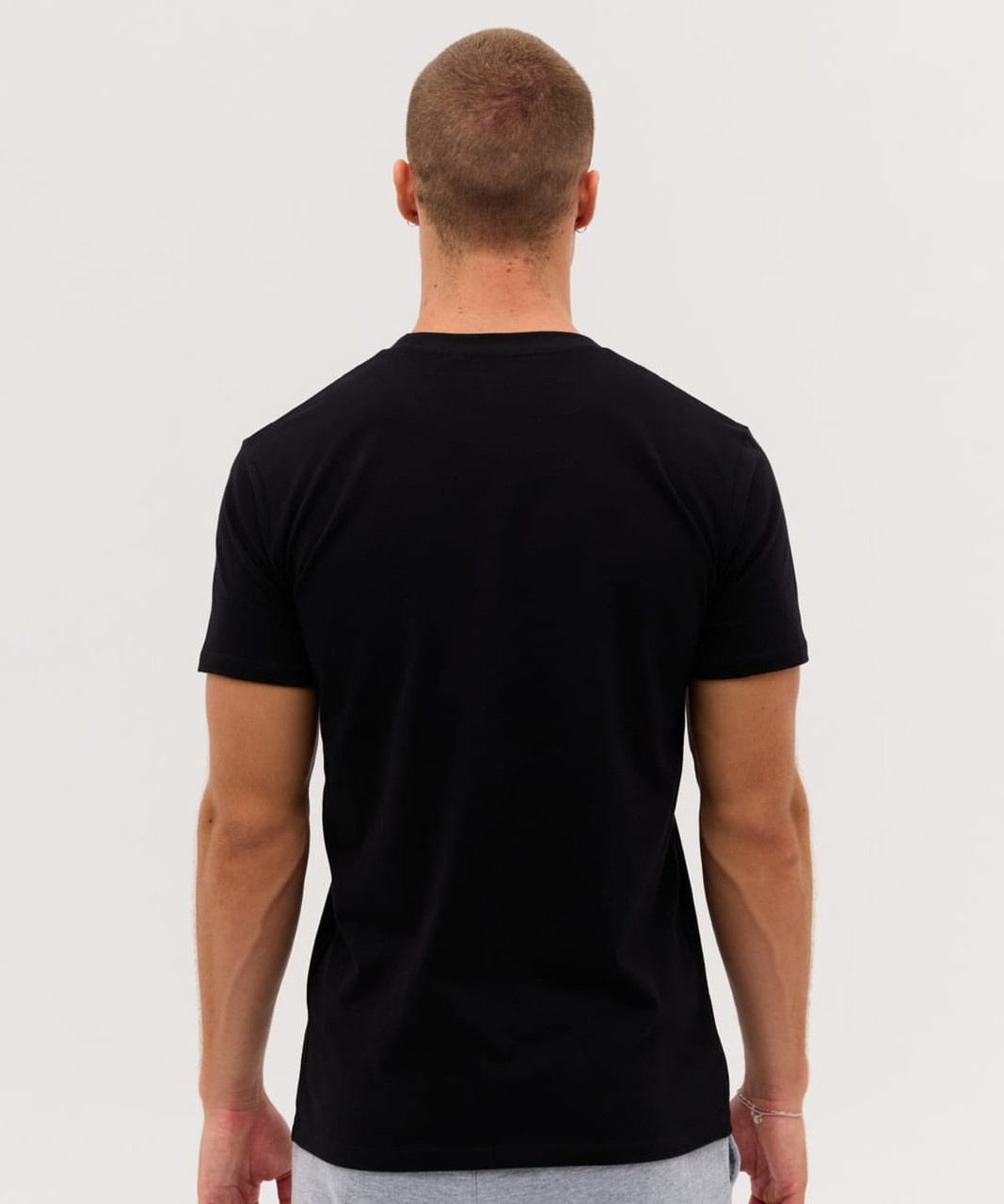A black T-shirt displayed from the back, featuring a fitted design and short sleeves. It has a logo on the rear.