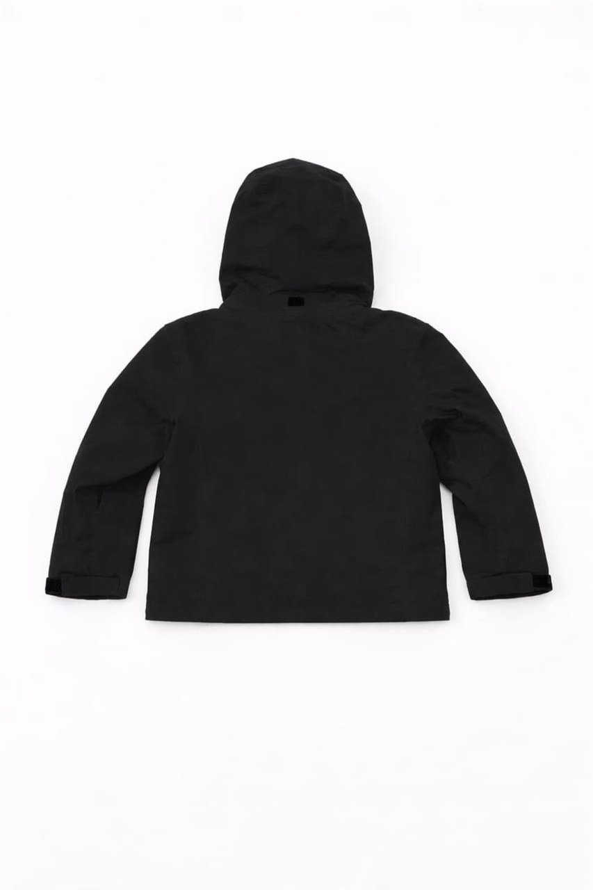 A black Youth Core Weather Jacket with a hood and long sleeves, featuring a logo on the back.