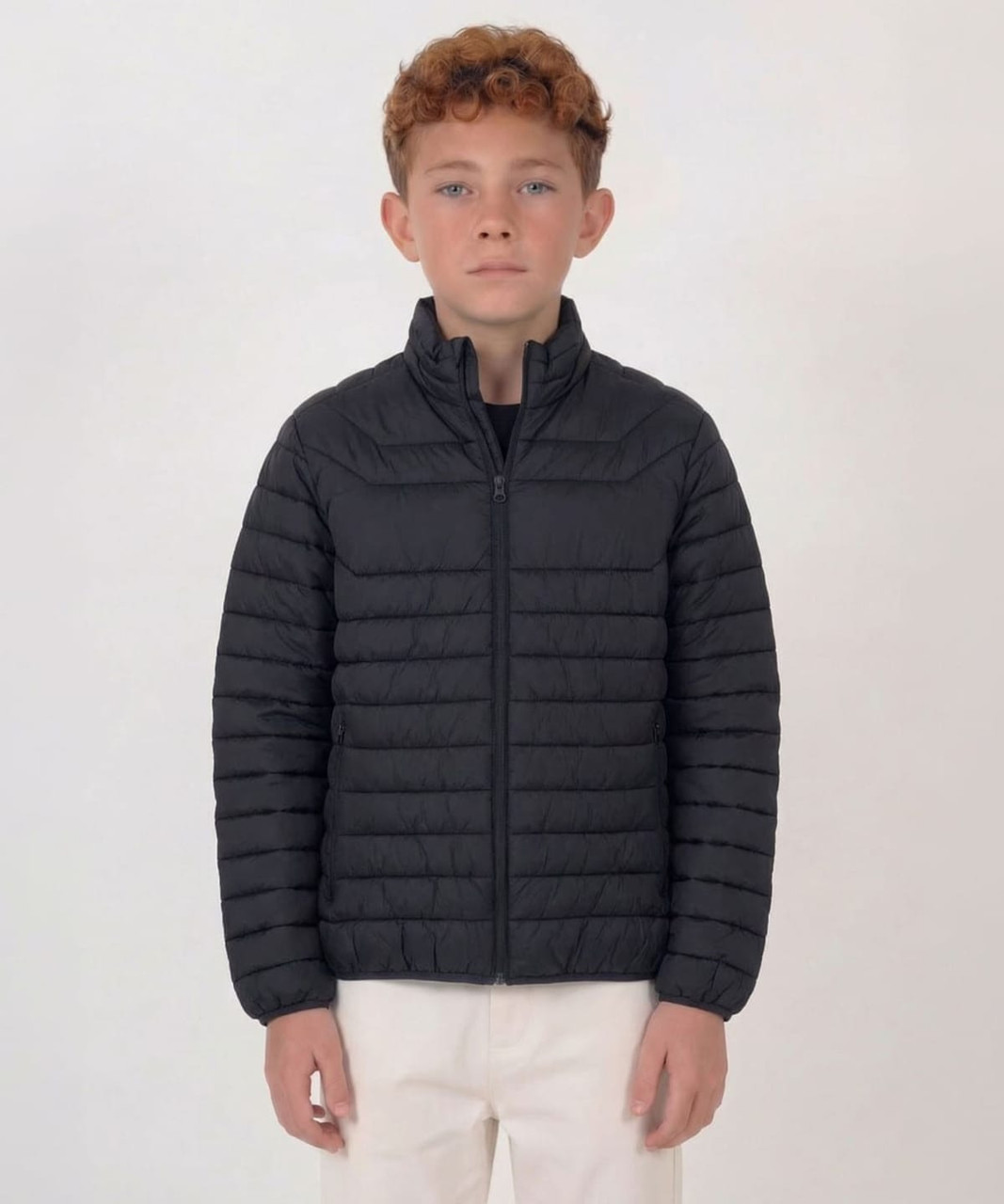 A puffer jacket in black, featuring a zip front and a sleek, padded design for warmth and style.