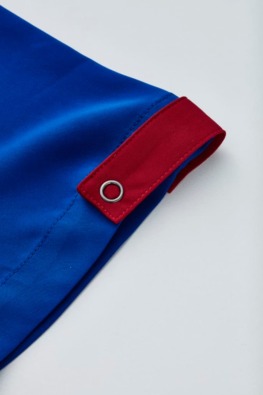A blue unisex scrub top featuring a red accent and a silver eyelet detail.