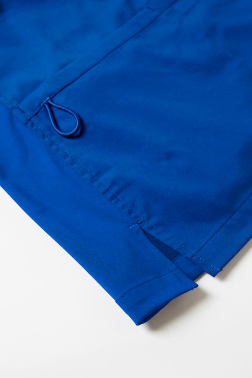 A blue women's scrub top featuring a side split and a drawstring detail. It has a logo on the fabric.