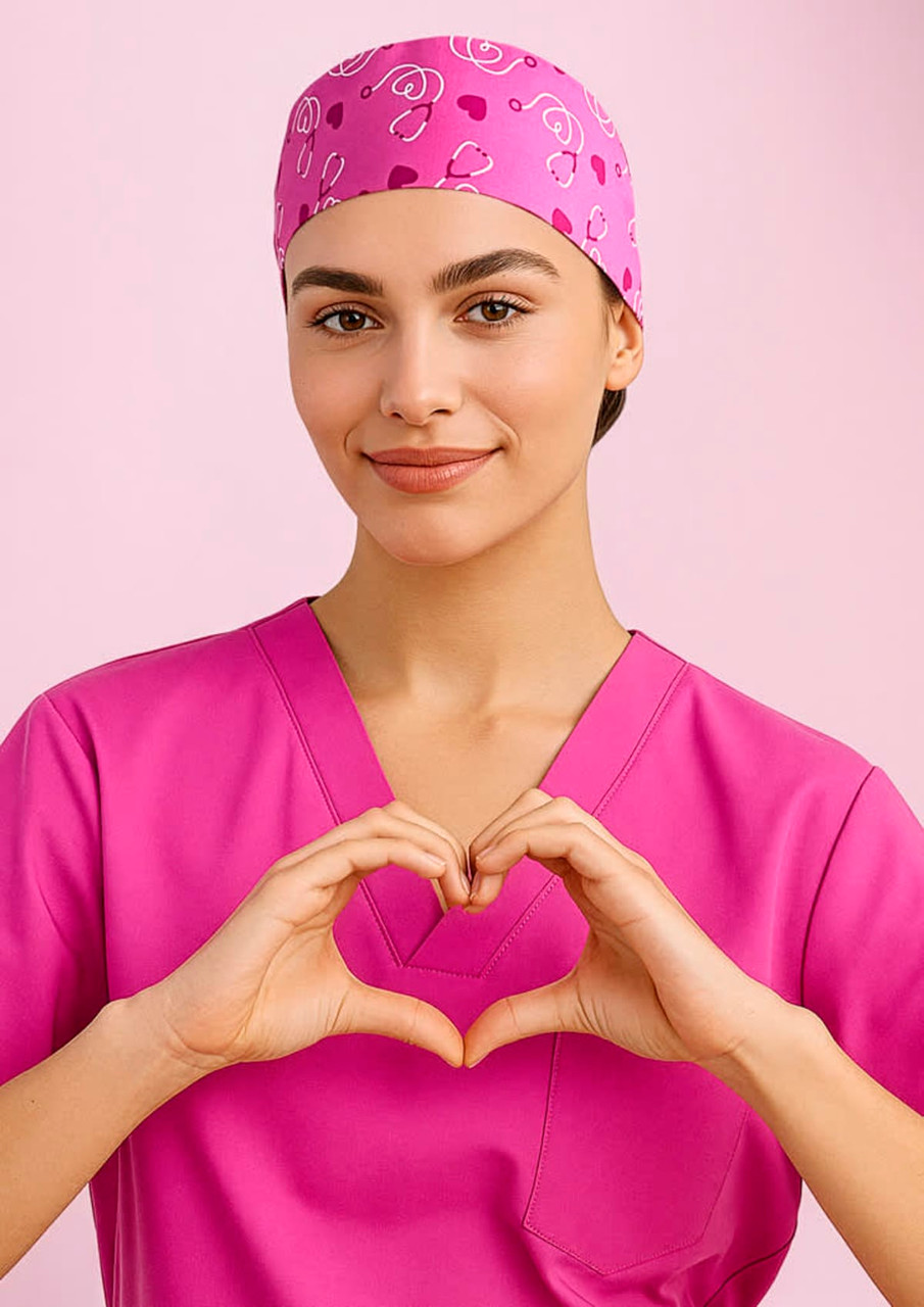 A unisex pink printed scrub cap with a patterned design, worn by a person in a matching pink scrub top.