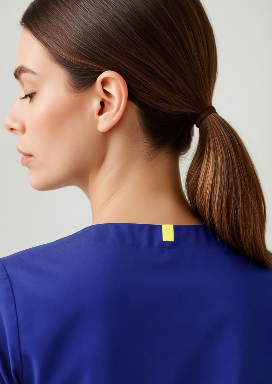 A unisex reversible scrub top in blue, featuring a simple design and a logo at the back neckline.