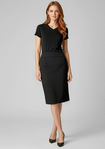 A fitted below-knee black skirt paired with a short-sleeved top, accompanied by high heels. The image features branding.