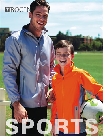 A reflective wet weather jacket in grey and orange worn by a man and a boy, both smiling on a grassy field.