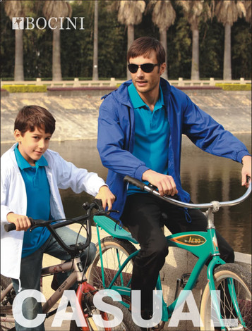 A blue unisex adults yachtsman's jacket is worn by an adult man riding a bicycle, alongside a boy on another bike.