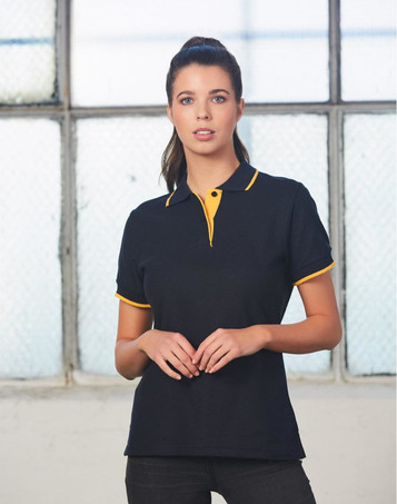 A black polo shirt with yellow accents, featuring a collar and a logo. The model stands in front of a window.