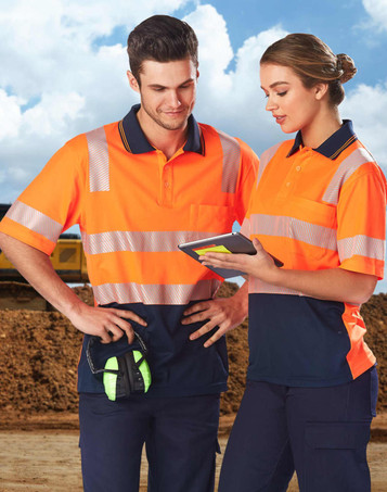 Two individuals wearing high-visibility orange and navy safety polo shirts with reflective stripes, standing outdoors.