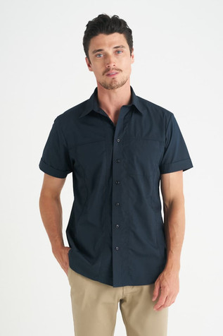 A navy short sleeve button-up shirt for men, featuring a collar and fitted style. The model stands casually with hands in pockets.