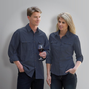 A blue button-up shirt for men displayed on a male model holding a glass of wine, with two front pockets.