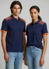A navy blue short sleeve polo shirt with contrasting orange accents and a logo. Worn by a male and female model.