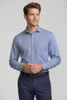 A men's long sleeve button-up shirt in light blue, featuring a chest pocket and a logo on the chest.