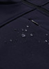 A dark navy softshell jacket with water droplets beading on the fabric, featuring a zippered pocket.
