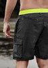 Men's board shorts in black with neon yellow accents, featuring a cargo pocket and a drawstring waistband.