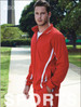 A model wearing red track pants and a matching zip-up jacket, featuring white stripes and a logo.