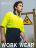 A man models a bright yellow and navy blue hi-vis polo shirt with a logo on it, set against an outdoor background.