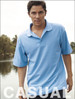 A light blue unisex polo shirt with a collar, being worn by a model outdoors near water.