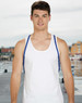 A model wearing a plain white tank top with blue straps, standing by a waterfront. The background features a dock and buildings.