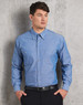 A blue chambray long sleeve shirt with two chest pockets and a button-up front, featuring a subtle brand logo.