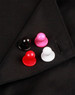 Four exchangeable buttons in black, red, pink, and white displayed on a black chef's uniform.