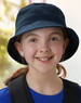 A navy soft washed bucket hat featuring eyelets, worn by a smiling child with a ponytail.