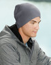 A grey cable knit beanie worn by a man in a grey jacket, set against a soft background.