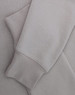 A light grey crewneck sweatshirt with a soft texture, featuring long sleeves and a cuffed hem.