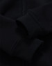 A black kid's full-zip fleecy hoodie featuring cuffed sleeves and a smooth texture. It has a logo on it.