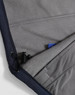 A close-up of a navy softshell hoodie featuring a grey fleece lining and a drawstring at the hem.